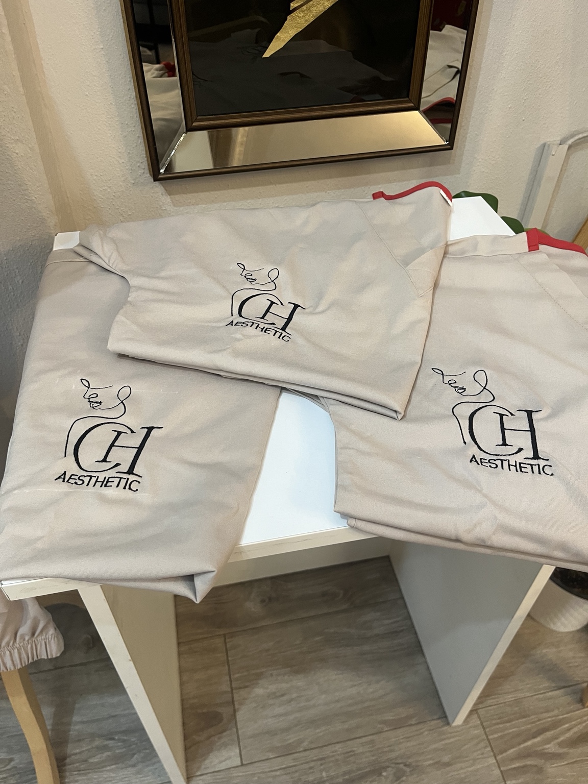 Completed clinic uniforms with custom CH Aesthetic logo embroidery
